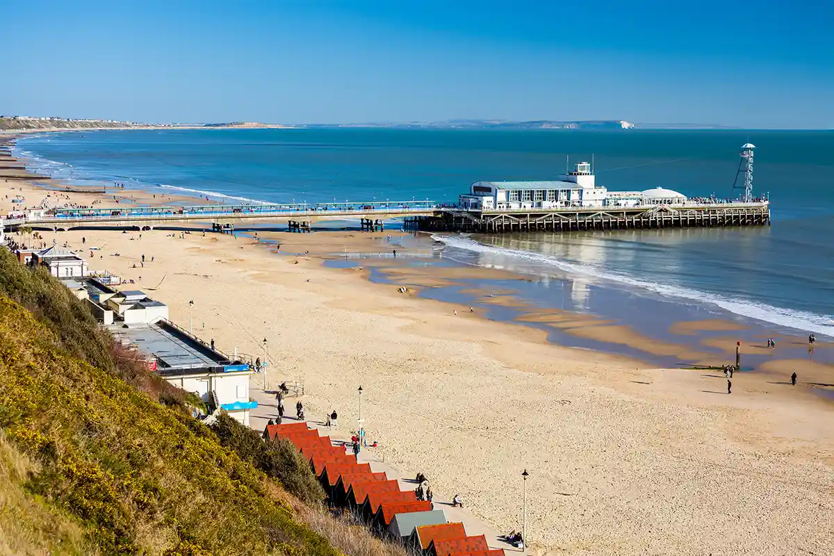 Bournemouth beach and pier on a sunny day with golden sand and clear blue sea.