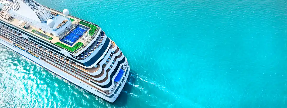 Cruise ship sailing on turquoise water.